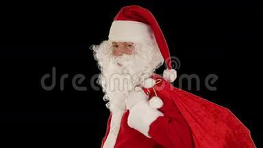 圣诞老人<strong>拎</strong>着包，看着镜头发来一个飞吻和挥<strong>手</strong>，黑色的，库存的镜头